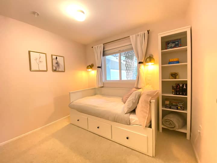The small third room has a cozy twin bed with large drawers. 