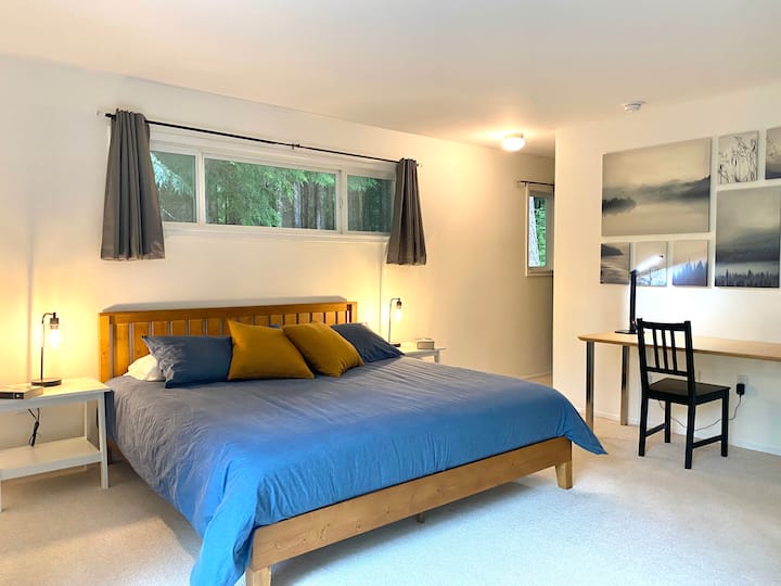 The large master bedroom has a private feel,  a master bath and a walk-in closet. Additional features are a TV and desk as well as large floor to ceiling windows facing the Calawah river.