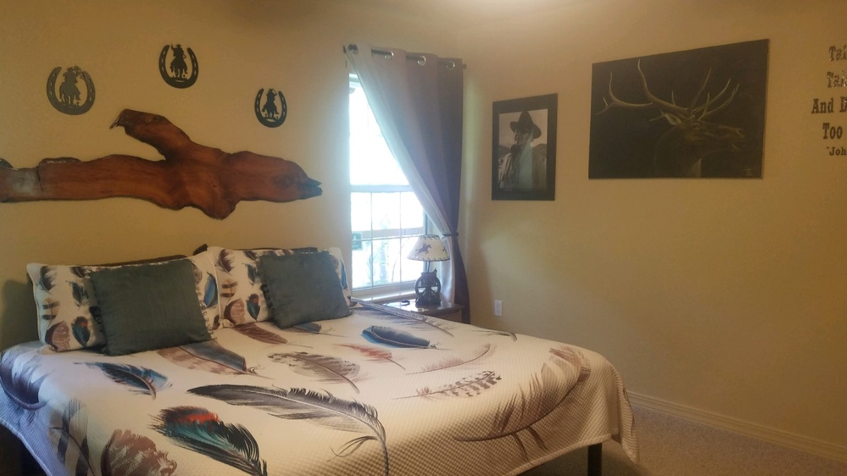 Ფართო საძინებელი დიდი საწოლით და ინდივიდუალური ელკის ნახატით, რომელსაც საჩუქრად იღებს მეგობარი და ადგილობრივი მხატვარი მარკ მაკბეი.