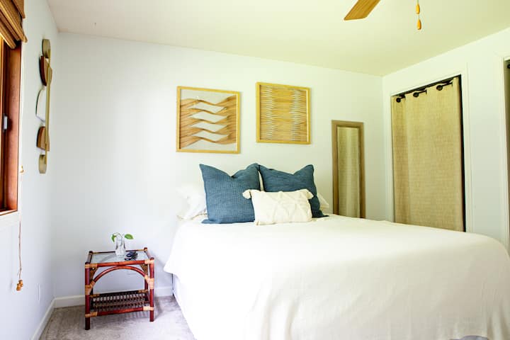 Dormitorio principal con cama tamaño queen, topper de espuma viscoelástica de tres pulgadas, escritorio de pie y TV de pantalla plana con Roku.