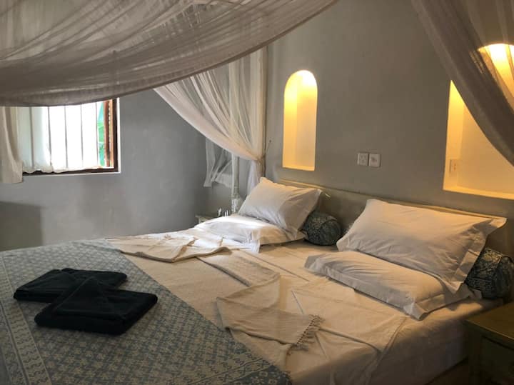 Este dormitorio, separado de la casa principal, cuenta con una cama tamaño king y un baño con ducha. También incluye una cama Lamu individual, perfecta para que un niño pequeño la comparta con sus padres.