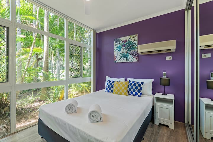 Chambre Queen au rez-de-chaussée avec grand peignoirs coulissants intégrés, climatisation et ventilateur de plafond.