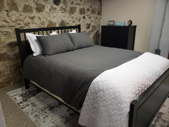 מרתף היציאה כולל את אזור חדר השינה הזה, הממוקם מול יסודות אבן השדה המקורית.