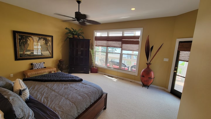 Spacious master bedroom with king bed overlooks the lake and back deck/patio