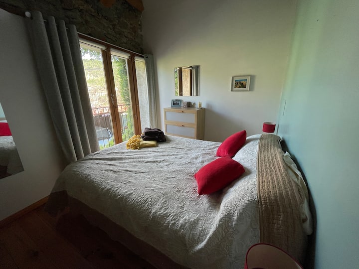 The master bedroom has a high, airy ceiling, a lovely double bed and a Juliet balcony that looks towards the mountains. It gets sun in the morning light and in the evening you can watch the hills light up with the setting sun. 