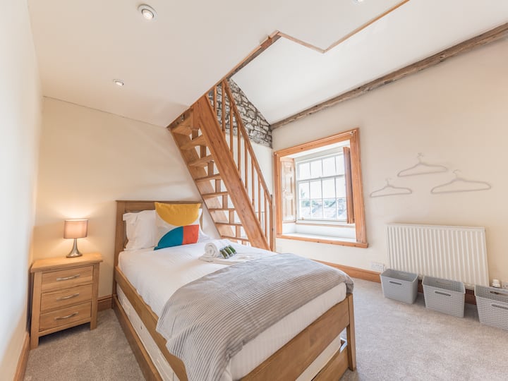 Eenpersoonskamer op de bovenste verdieping met uitschuifbed en ruimtebesparende trap naar loftruimte
