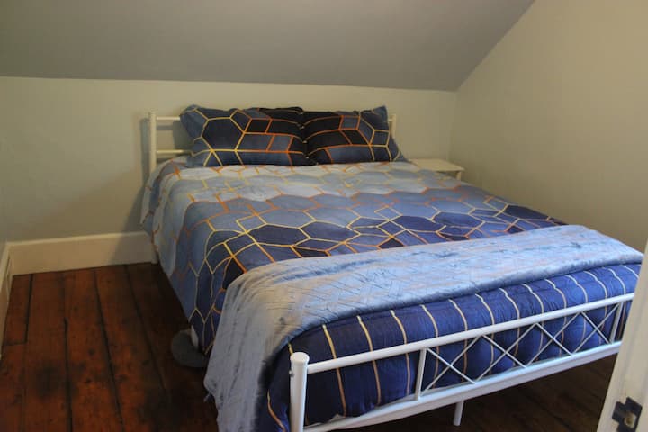 El dormitorio pequeño en el segundo piso (cama tamaño queen) tiene una mesita de noche y armario.