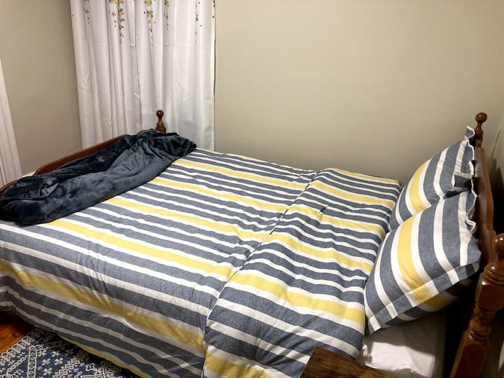 El dormitorio pequeño en el primer piso (cama tamaño queen) tiene una mesita de noche y armario.  