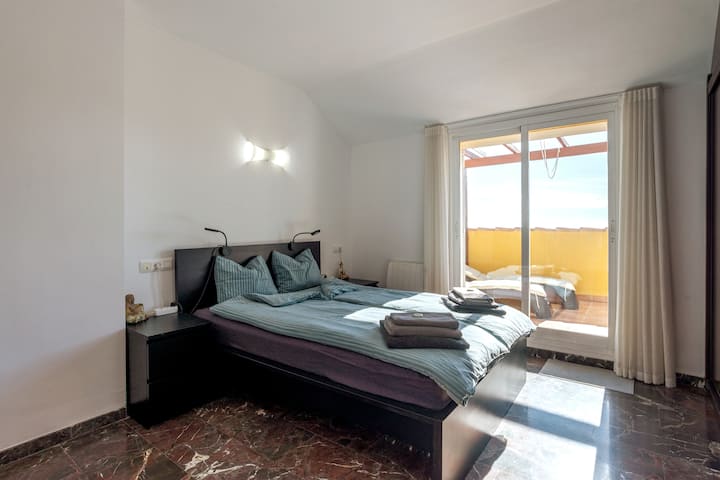 ห้องนอนใหญ่มีตู้เสื้อผ้าติดตั้งและทางเข้าระเบียง