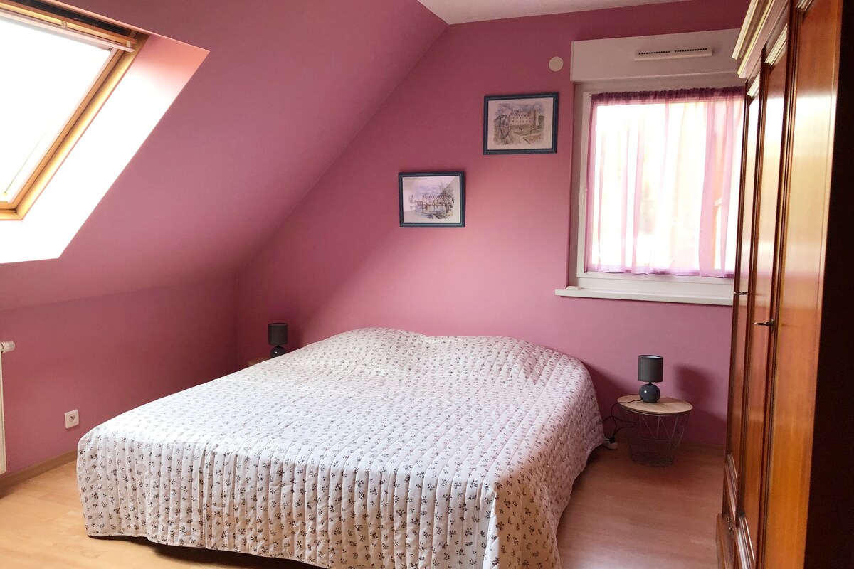 ห้องพักสีม่วงพร้อมเตียงคู่ขนาดคิงไซส์และตู้เสื้อผ้า