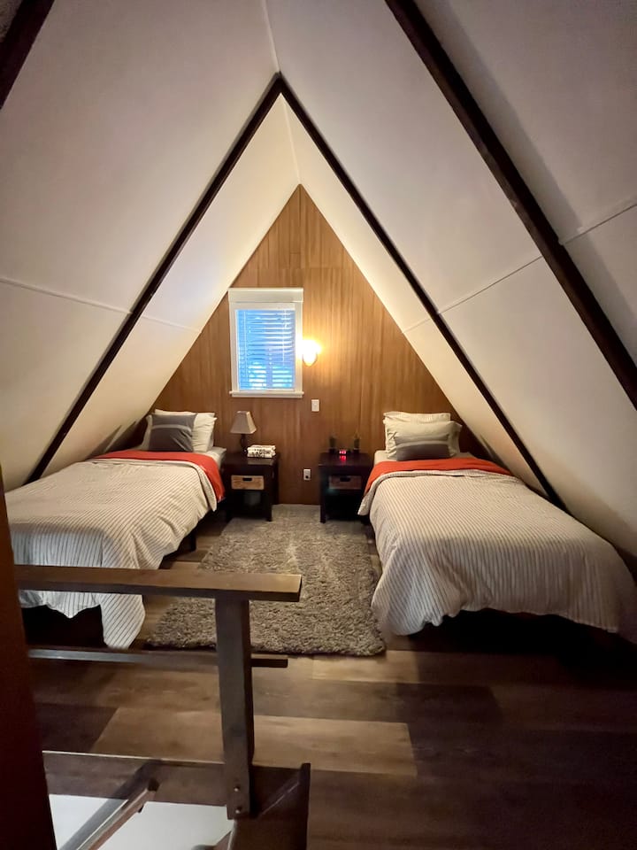 Twin beds in loft like space open to living room below