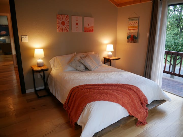 Високите сводести тавани и голямото двойно легло създават просторно място за отдих. Големите стъклени врати внасят слънчева светлина и гледки към дивата природа, а плътните завеси гарантират спокоен сън през нощта.