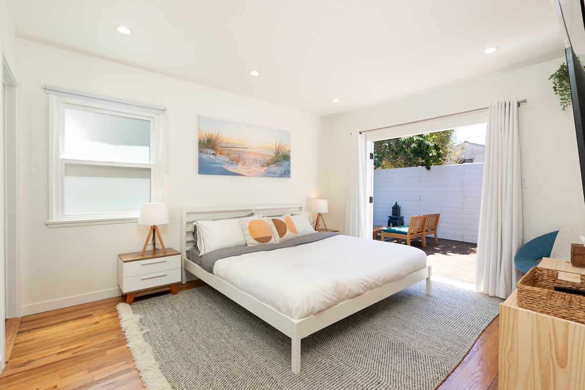 Dormitorio principal con cama tamaño king; las puertas francesas se abren a la terraza.