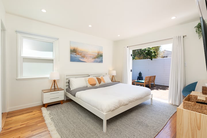 Dormitorio principal con cama tamaño king; las puertas francesas se abren a la terraza.