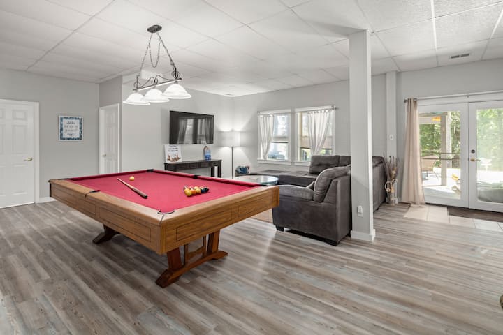 Всекидневна на долния етаж с голям екран, билярдна маса и трапезария