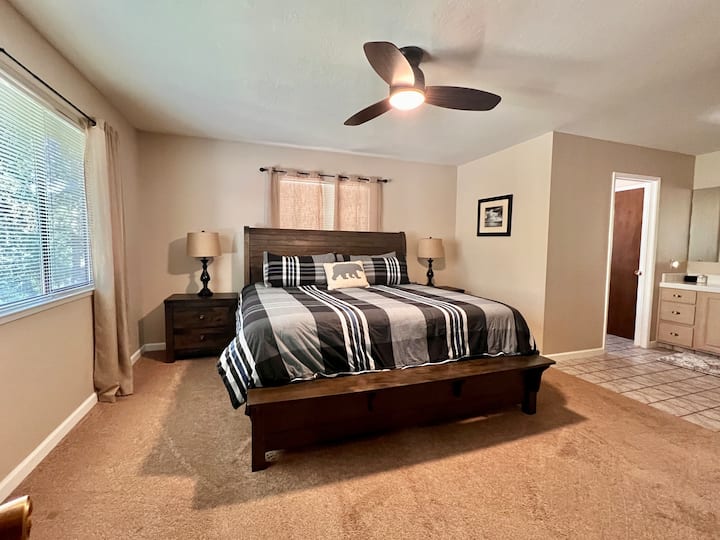 Master bedroom has all new furniture, a walk-in closet, large vanity, 55" smart TV, and a small desk.