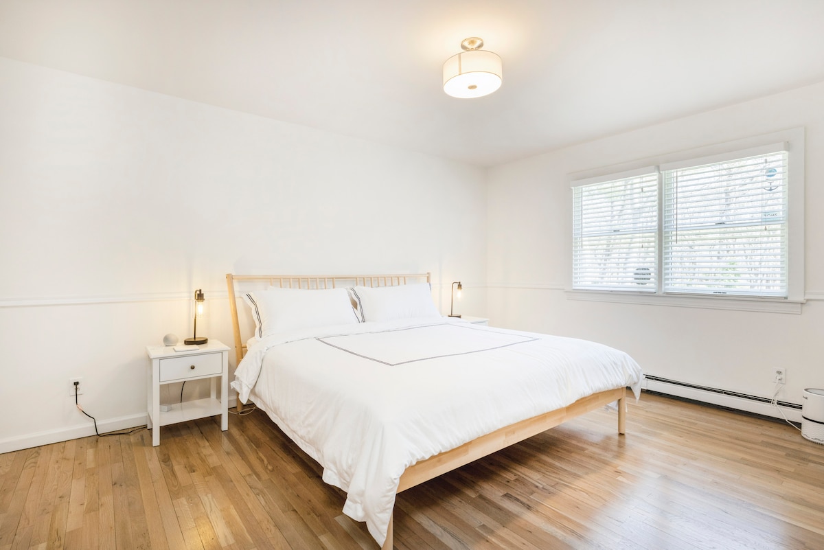 ห้องนอนผู้เข้าพักพร้อมเตียงขนาดคิงไซส์ตู้เสื้อผ้าขนาดใหญ่และโต๊ะข้างเตียงรวมถึงไฟพร้อมที่ชาร์จ USB