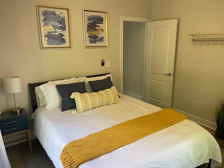 El acogedor dormitorio tiene una cama tamaño queen, mesa auxiliar y vestidor. Hay cortinas opacas completas y puertas francesas dobles que se abren al área de la piscina.