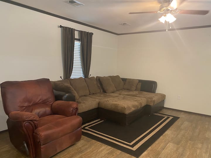 Open layout living room with recliner and comfortable oversized couch that can be used as a 3rd sleeping area.