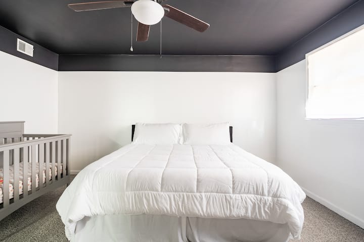 חדר שינה ראשי עם מיטת קינג סייז ועריסה לפעוט. 