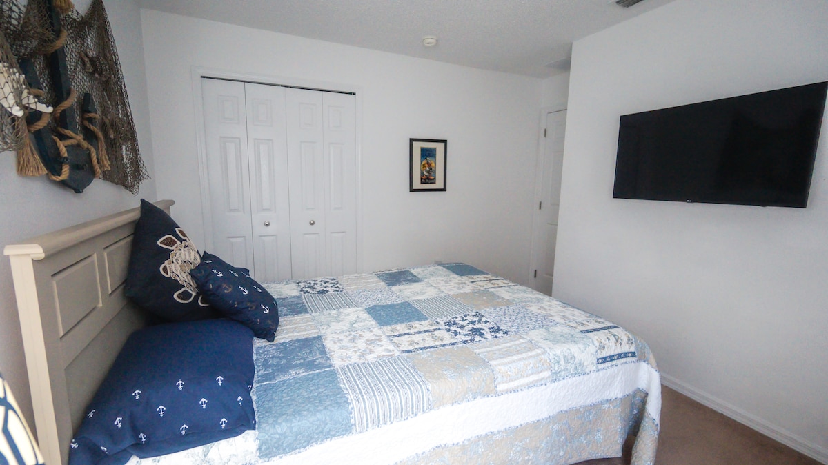 Queen Bedroom 2 with large 43" LG UHD 4K smart television, and Alexa enabled lighting.