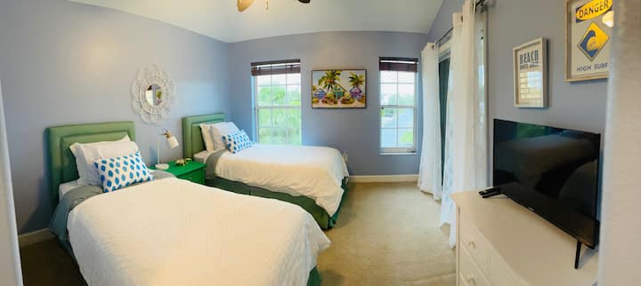 Chumba cha kulala cha tatu kina vitanda viwili pacha, runinga, kabati la kujipambia, nafasi ya kabati na baraza inayoongoza kwenye sitaha ya kutazama sakafu ya tatu.