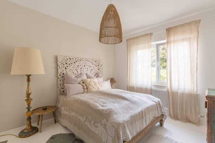 Hauptschlafzimmer und das Fenster mit Blick auf die Palme im Vorgarten in der Morgensonne.