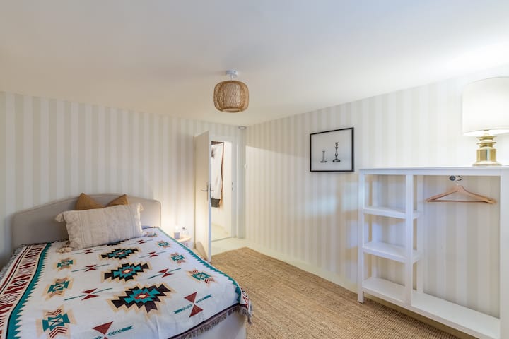Schlafzimmer 3 im Souterrain mit kleinem Fenster mit Blick auf den Vorplatz und die Morgensonne.