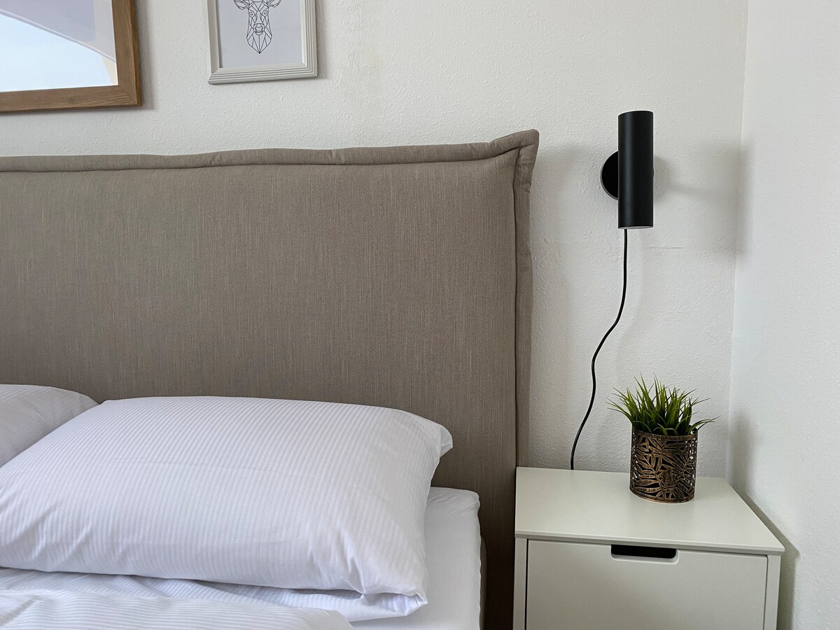 View of the bedroom with cozy box spring bed (approx. 160 x 200 cm)