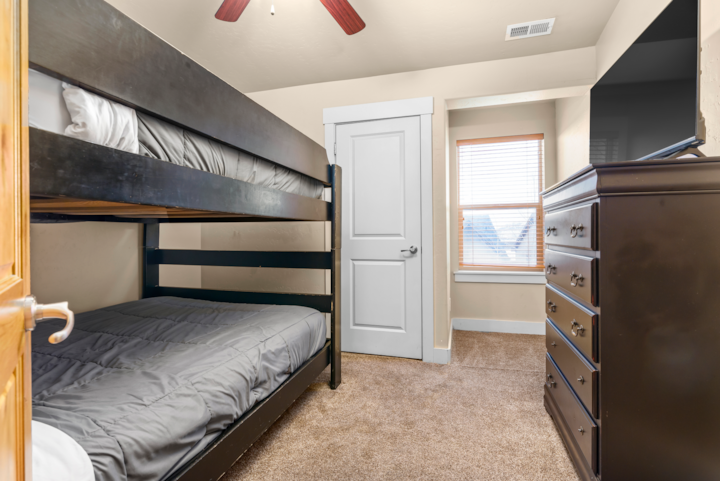 غرفة بطابقين بمقاس كوين مع تلفزيون عالي الوضوح مقاس 43 بوصة وبجودة 4 K.