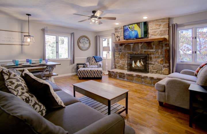 开放式概念起居空间，供您和您的同行者聚集在舒适的沙发上，或在燃木壁炉前面的农舍桌子周围。