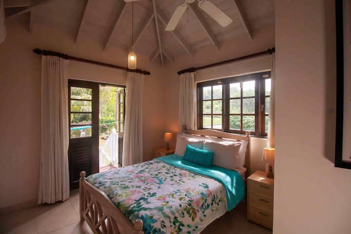 Main level guest bedroom 1 with double bed, clean linens, direct outside access to balcony, ceiling fan, air conditioning, closet, private en-suite 3 piece bathroom with shower. 