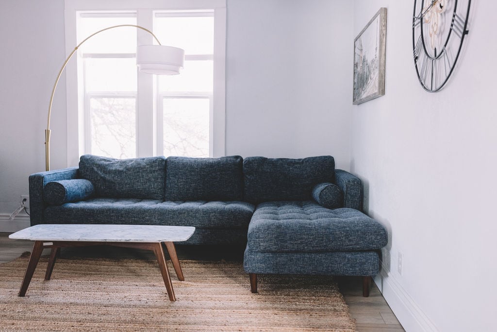 Divan i rehatshëm seksional dhe një tavolinë kafeje mermeri.