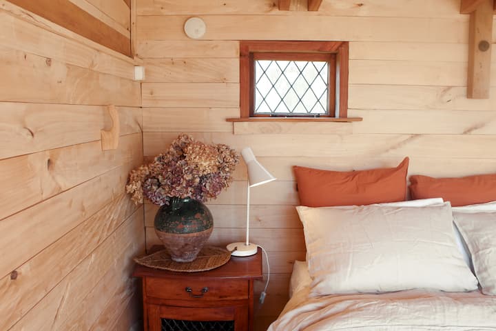 The cabin has a comfortable queen-sized bed. Two bedside cabinets provide storage for your belongings.