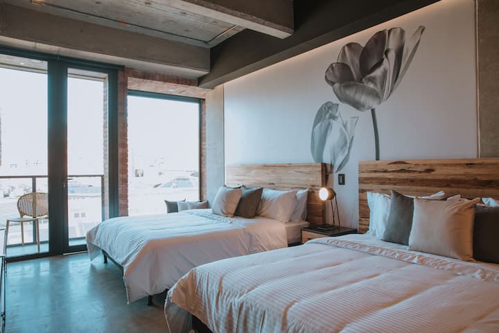 Dormitorio con aire acondicionado, baño y balcón.