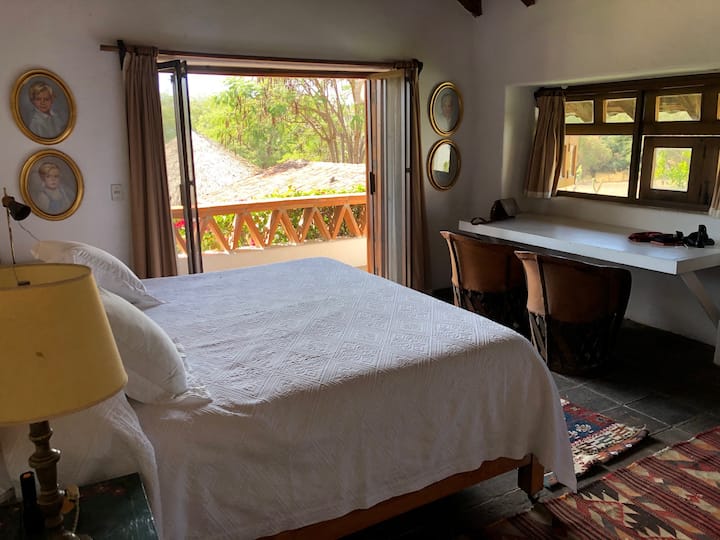 El dormitorio principal está en el segundo piso de la casa principal. Tiene una cama king y un escritorio lo suficientemente grande para dos personas.  El balcón tiene una hermosa vista a la piscina y al jardín. Los huéspedes que duerman aquí deben subir las escaleras (una planta). 