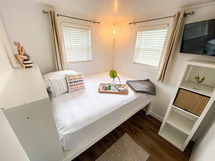 Bedroom featuring a queen sized bed and a 32 inch Smart TV.