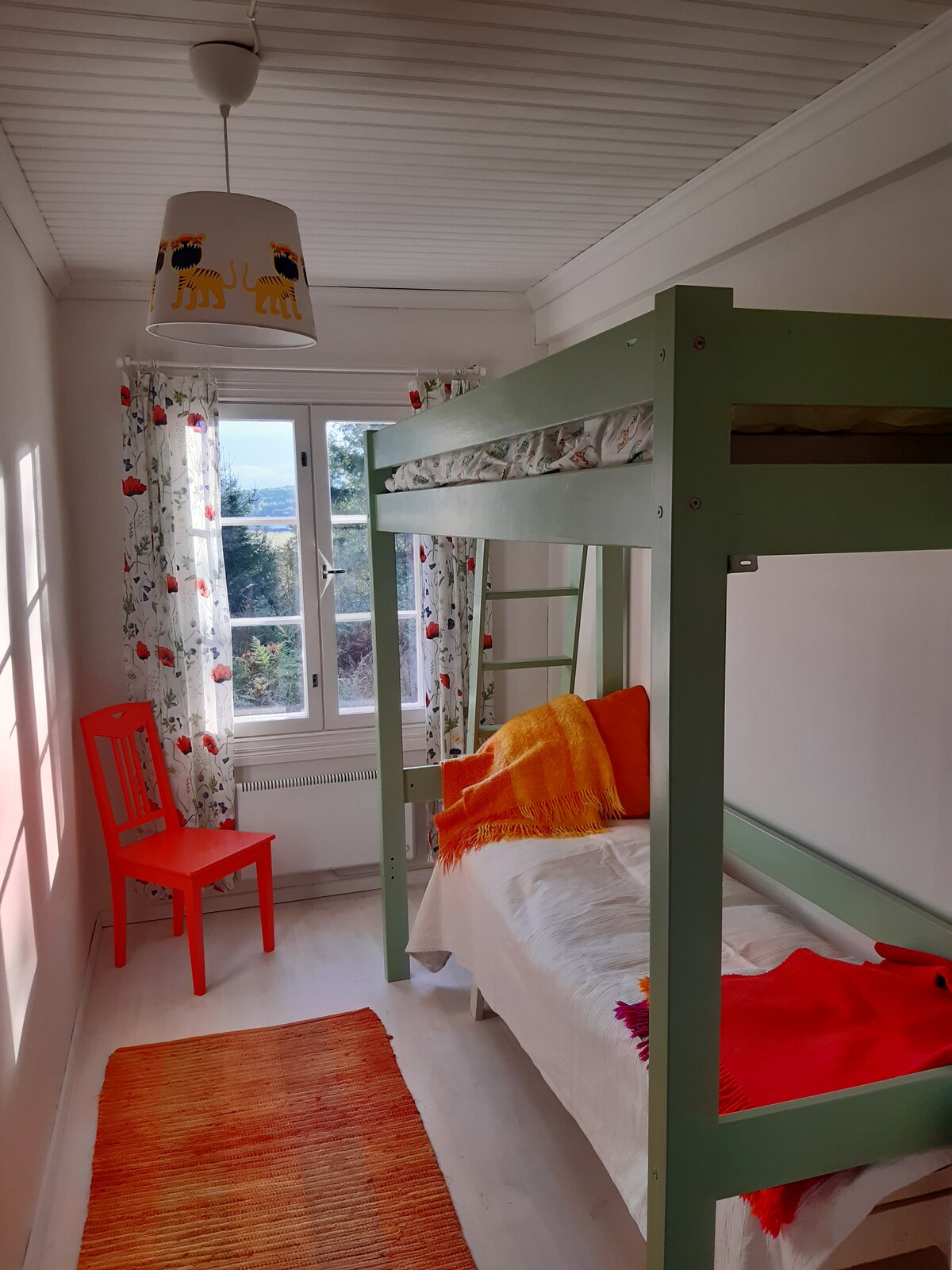 阳光明媚的小卧室配有一张80厘米宽的双层床，下方有一张标准双人床。