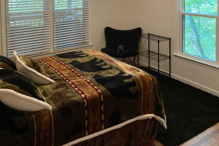 Საძინებელი მთავარ მხარეს, ხის სახლის უკანა მხარეს, ორადგილიანი საწოლით. 