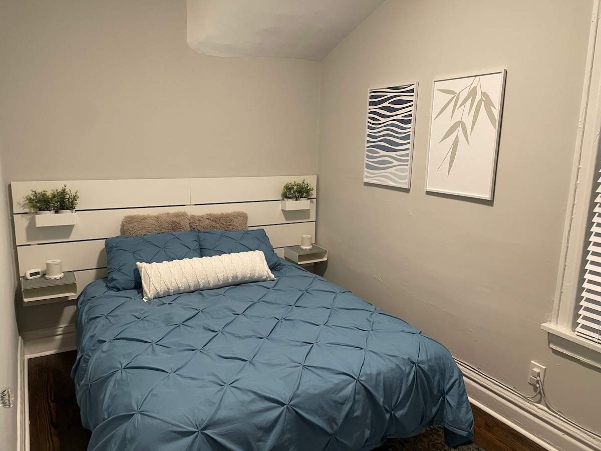 غرفة نوم أمامية مع تلفزيون كبير.