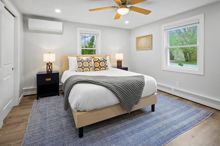 King size bed in a cozy setting in the guest bedroom with a 65" smart TV, noise machine, phone chargers, blackout shades.