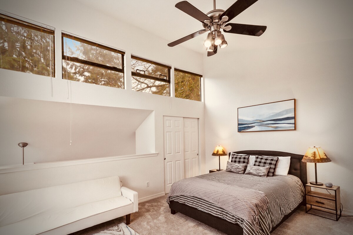 Ლოფტის ოთახი მყუდრო საწოლითა და ტახტით, რომ დაისვენოთ და წაიკითხოთ წიგნი.