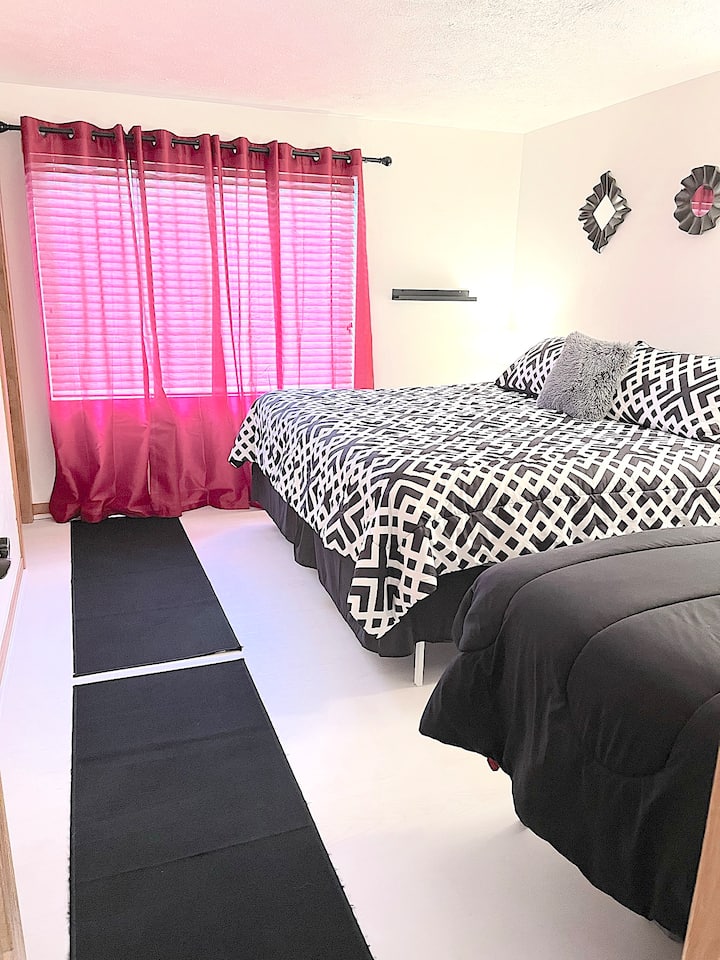 חדר שינה 2 (חדר אדום) עם מיטת קינג סייז, מיטה זוגית וחדר רחצה צמוד.