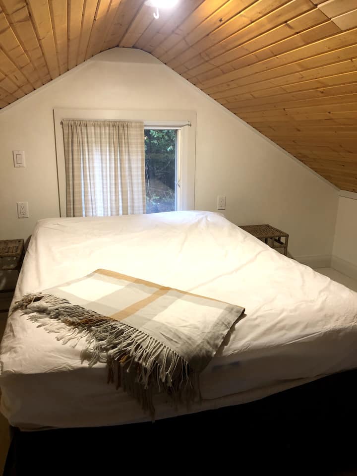 The loft bedroom is furnished with a double bed and two small side tables. Please note: bed linens are not included.
