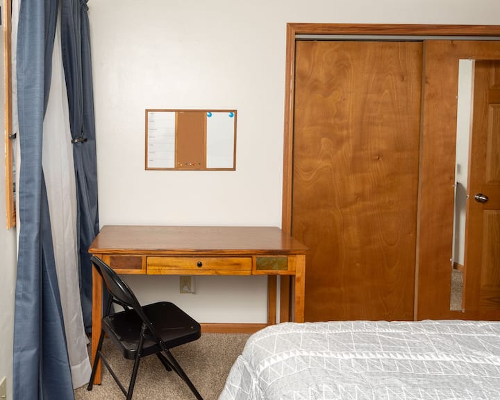 mesa y silla en el dormitorio para un pequeño espacio de trabajo de oficina