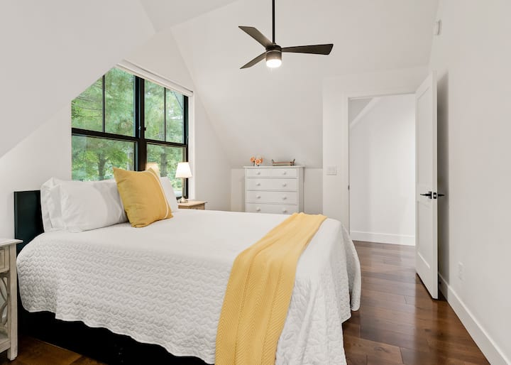 The third upstairs bedroom features cheery yellow accents on its queen bed and in its ensuite bathroom.