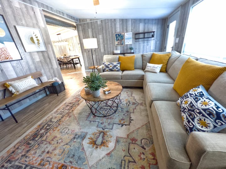 Huge sectional with comfortable pillows, view of the dining room, and large windows looking out to the forest and patio.  