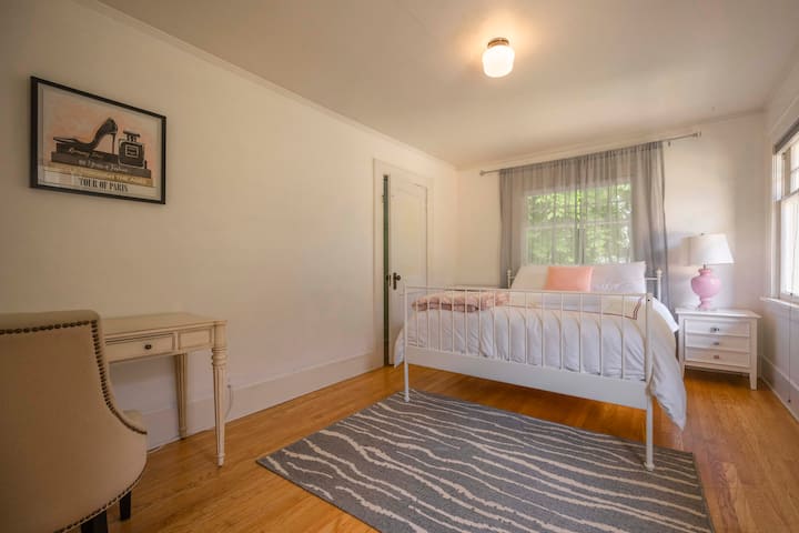 Dormitorio con cama tamaño queen y escritorio.