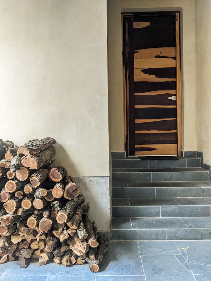 4号卧室（月亮双床房）的入口，旁边有一堆木柴。