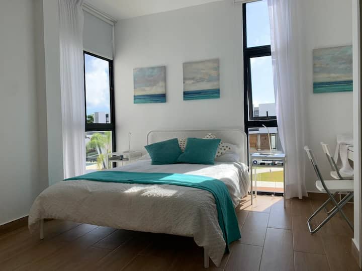 חדר שינה ראשי עם מיטת קווין סייז, מיזוג אוויר, חדר ארונות מאובזר ושולחן עבודה לשני אנשים.